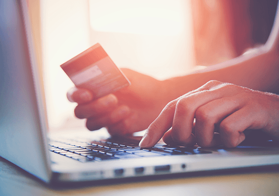Photo of person making credit card payment on laptop.